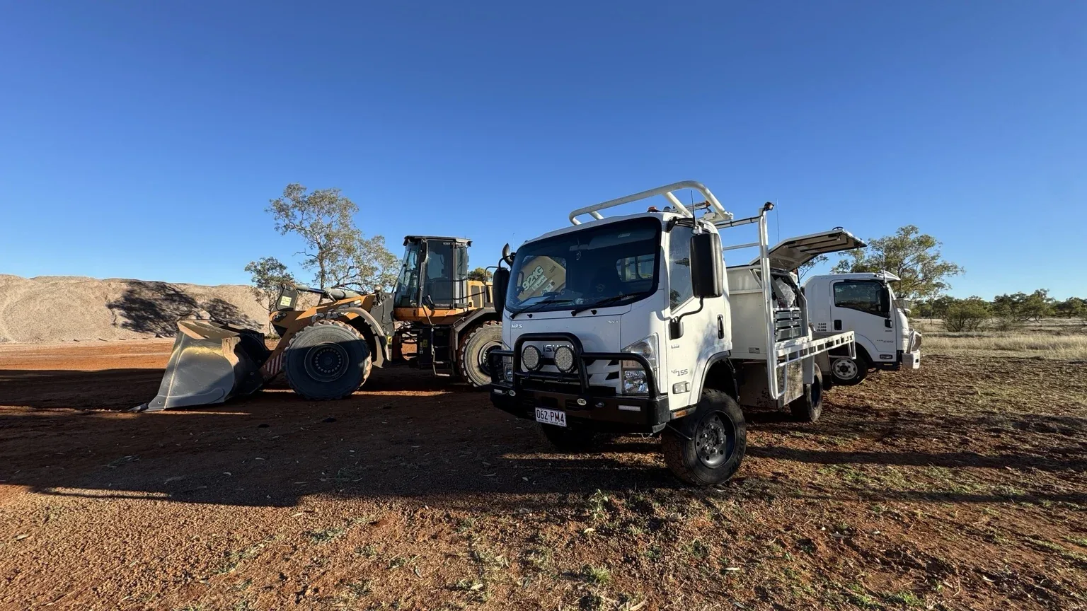 12Mech service truck working alongside a wheel loader on a red dirt site